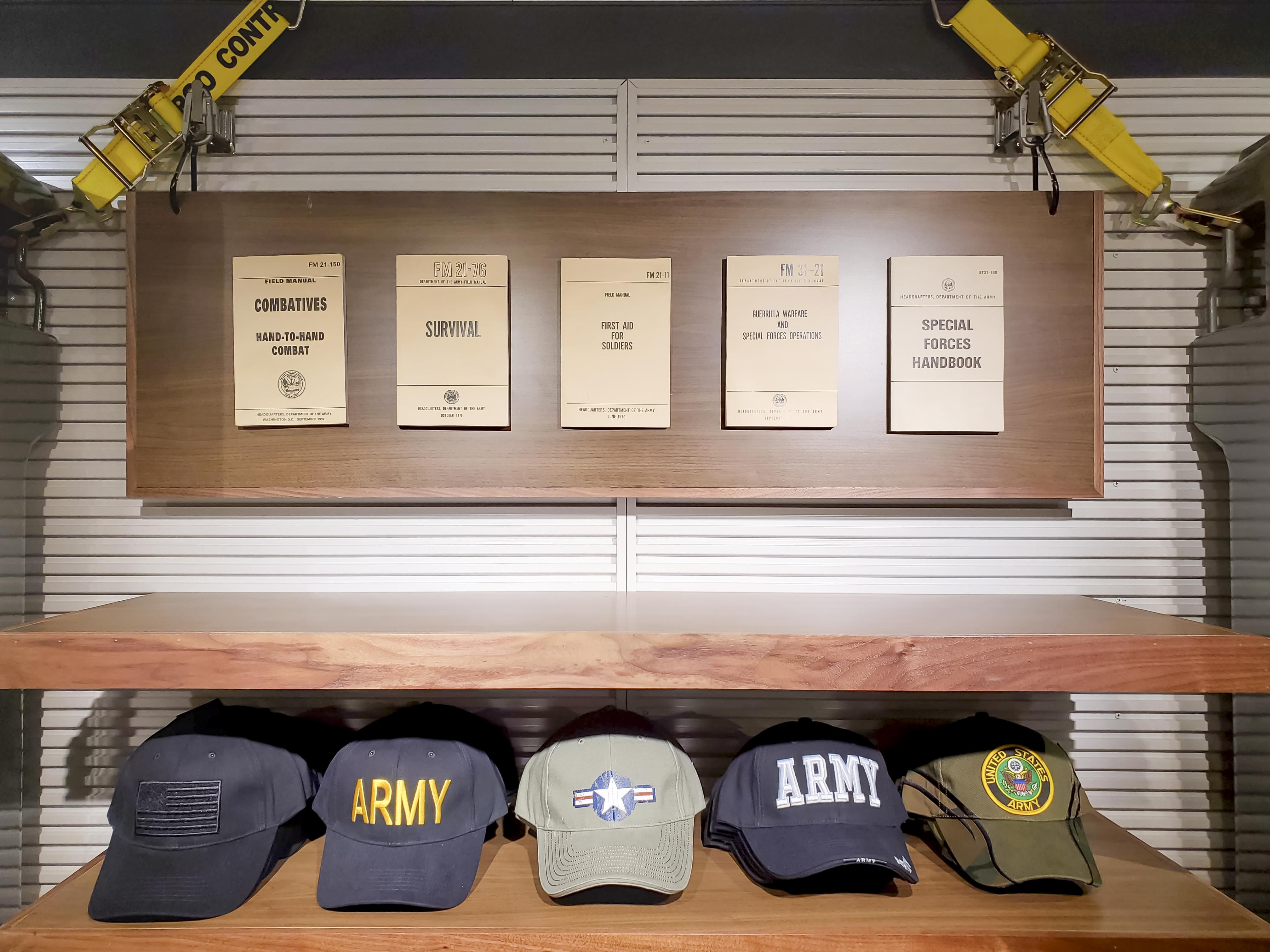 Painted helmets mounted over a relief of upcycled green army men — conservation as graphic