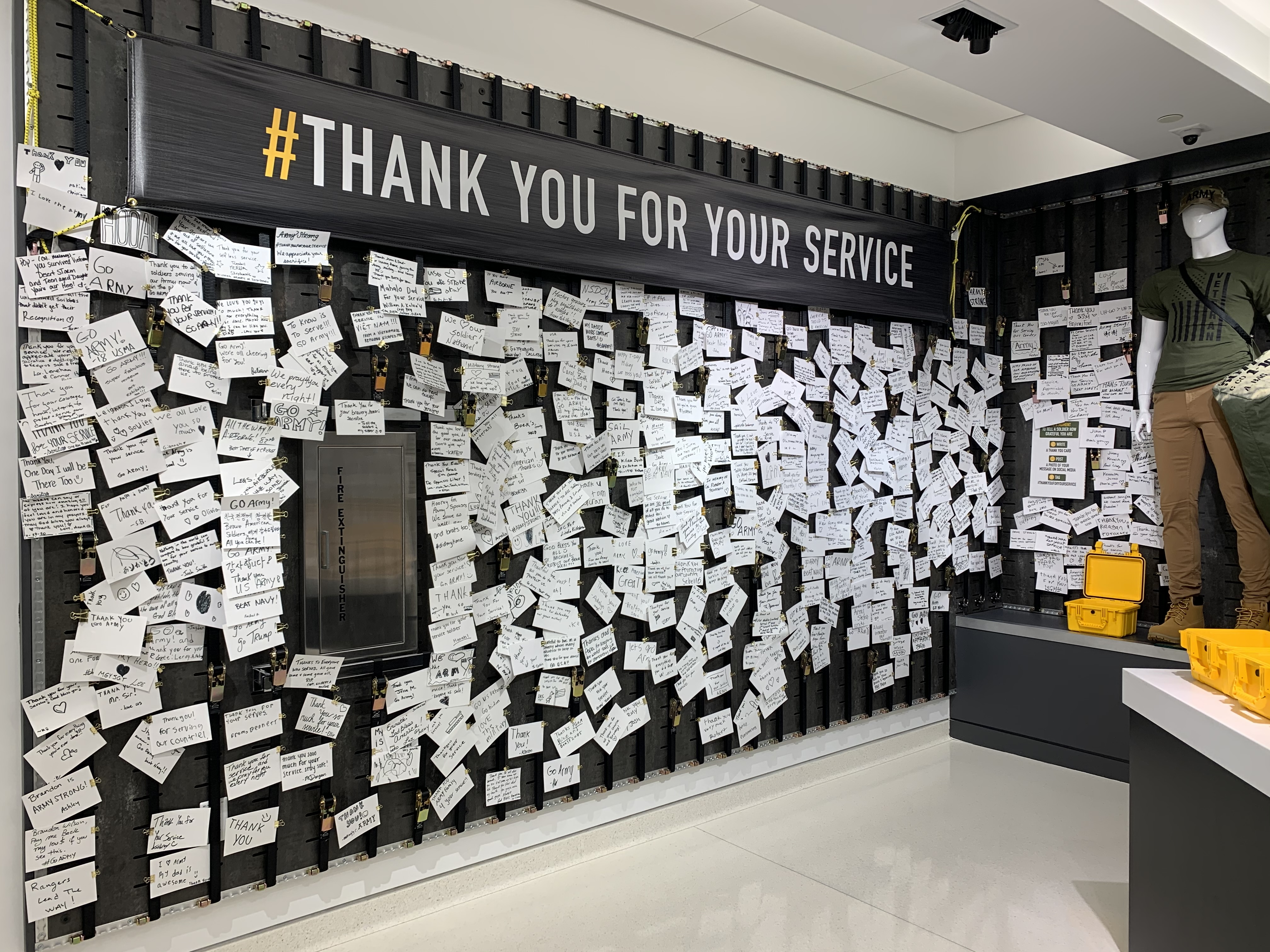 The #ThankYouForYourService card wall — visitors pin handwritten notes to a soldier